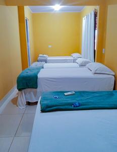 Habitación con 3 camas en una habitación en Pousada Voadores Jalapão en Mateiros