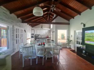 Una cocina y un comedor con una mesa y sillas blancas. en Alquiler temporario Tandil LAS PALMERAS I, en Tandil