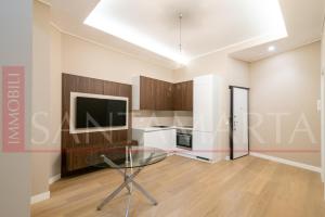 a living room with a glass table and a kitchen at Porta Venezia New Luxury apt - wifi full equiped in Milan