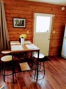 een eetkamer met een tafel en stoelen en een deur bij River Retreat Cabin in Three Rivers - near SNP in Three Rivers