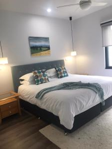 Gillys Guesthouse في ميتونغ: غرفة نوم بسرير كبير عليها مخدات