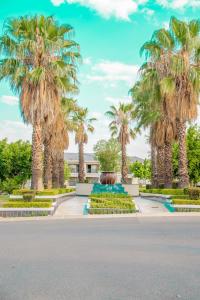 a park with palm trees in front of a building at La casa de Miah in Sandton