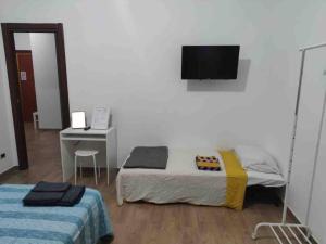 1 dormitorio con 1 cama y TV en la pared en Appartamento Centocelle vicino Metro C, en Roma