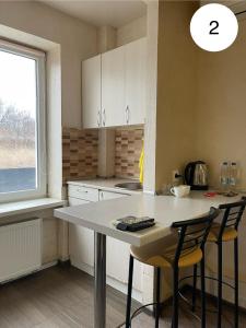 een keuken met een tafel en 2 stoelen en een raam bij Ideal KH apartments in Charkov