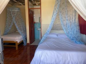 Schlafzimmer mit einem Bett mit Moskitonetz in der Unterkunft LA CASA DE YOLA in Máncora