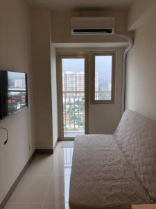 ein Schlafzimmer mit einem Bett und einem großen Fenster in der Unterkunft SMDC Coast Residences - The Happy Place in Manila