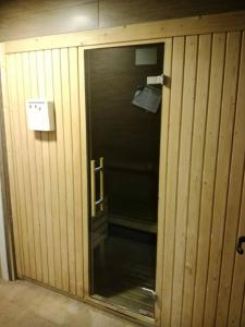 Cette chambre en bois dispose d'une salle de bains avec une porte en verre. dans l'établissement Habitacion con Piscina y Sauna, à Sant Cugat del Vallès