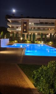 - un grand bâtiment avec une grande piscine la nuit dans l'établissement Habitacion con Piscina y Sauna, à Sant Cugat del Vallès