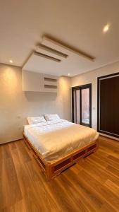 ein Schlafzimmer mit einem Bett in einem Zimmer mit Holzböden in der Unterkunft Appartement à 14 min de la place Jamaà el Fna in Marrakesch