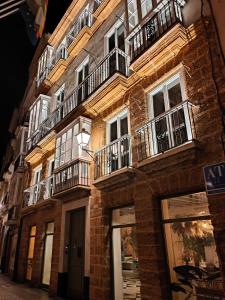 un edificio de ladrillo con balcones en una calle en VG - Villa de Andas suites, en Cádiz
