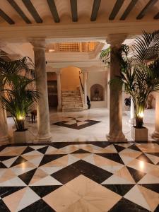 eine Lobby mit schwarz-weiß kariertem Boden in der Unterkunft VG - Villa de Andas suites in Cádiz