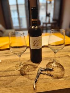a bottle of wine and two glasses on a table at VG - Villa de Andas suites in Cádiz