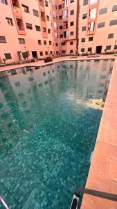 ein Schwimmbad in der Mitte eines Gebäudes in der Unterkunft Appartement à 14 min de la place Jamaà el Fna in Marrakesch