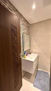 ein Bad mit einem Waschbecken und einem Spiegel in der Unterkunft Appartement à 14 min de la place Jamaà el Fna in Marrakesch