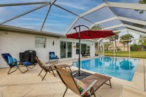 a patio with a table and chairs and a pool at Riverfront Florida Retreat with Pool, Patio and Grill! in Port Charlotte