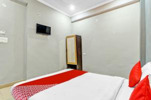 1 dormitorio con 1 cama y TV en la pared en Orphic Inn Near Munshi Pulia Metro Station, en Chinhat