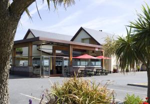 a building with tables and umbrellas in a parking lot at The Farmers Kitchen Hotel in Wexford
