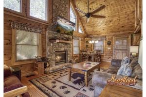a living room with a fireplace in a log cabin at Mountain Memories Is A Perfect Mountain Getaway For A Family Or Couples Retreat! in Sevierville