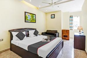 een hotelkamer met een bed en een stoel bij Townhouse Prakash continental Near Netaji Subhash Place Metro Station in New Delhi