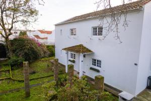 een wit huis met een hek ervoor bij Casa da Abelheira in Ponta Delgada