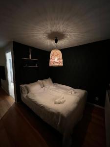 - une chambre avec un lit blanc et un mur noir dans l'établissement Mysig lägenhet!, à Göteborg