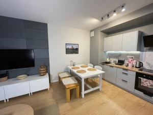 a kitchen with a white table and a counter at Essence Lux Apartment, free parking, self check-in 24h in Poznań