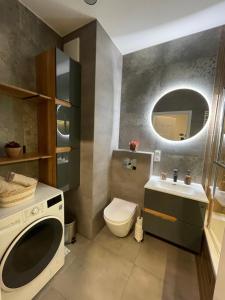 a bathroom with a toilet and a sink and a washing machine at Essence Lux Apartment, free parking, self check-in 24h in Poznań +41 photos