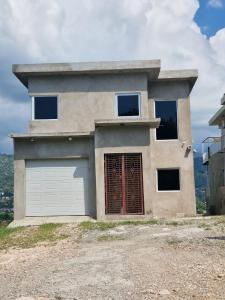 a house with a garage on top of a hill at Amharic in Kingston