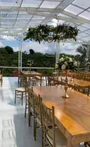 une salle à manger avec des tables en bois, des chaises et des fleurs dans l'établissement Cabitat Cabañas, à Quimbaya