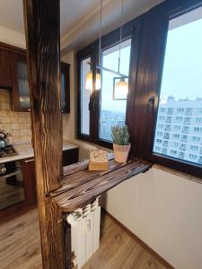 Una cocina con encimera de madera con dos ventanas. en Kukuryku Apartament Centrum, en Katowice