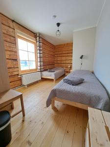Schlafzimmer mit Holzwänden, einem Bett und einem Fenster in der Unterkunft ZELTA KROGS 