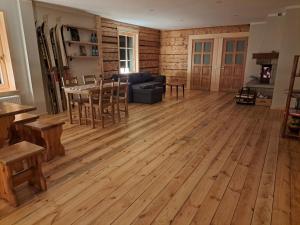 ein Wohnzimmer mit Holzböden sowie einem Tisch und Stühlen in der Unterkunft ZELTA KROGS 