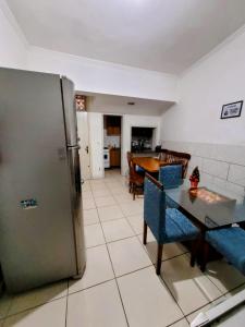 a kitchen and dining room with a stainless steel refrigerator at Man's Place Hostel Masculino in Porto Alegre