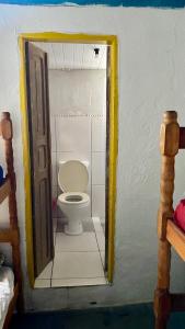 Casa Lee Hostel في باراتي: حمام مع مرحاض في غرفة صغيرة