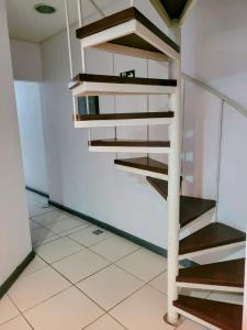 a spiral staircase in a room with white tiles at Man's Place Hostel Masculino in Porto Alegre