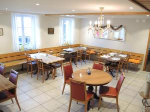une salle à manger avec des tables et des chaises dans un restaurant dans l'établissement Hotel Restaurant Alpenblick, à Wolfisberg