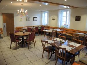 une salle à manger avec des tables et des chaises ainsi qu'un lustre dans l'établissement Hotel Restaurant Alpenblick, à Wolfisberg