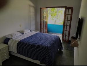 una camera con letto, TV e porta di Casa para temporada - Guarujá - Praia Pernambuco a Guarujá