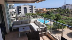 a balcony with a couch and a view of a pool at Green Hills La Zenia-Luxury 3 bed Apartment in Los Dolses