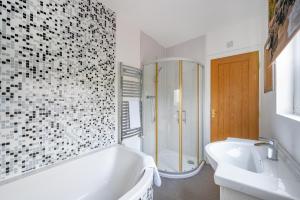 a bathroom with a tub and a shower and a sink at *RB98BL* For your most relaxed & Cosy stay + Free Parking + Free Fast WiFi * in Farnley