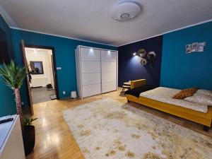 1 dormitorio con cama y pared azul en Różana 4, en Nałęczów