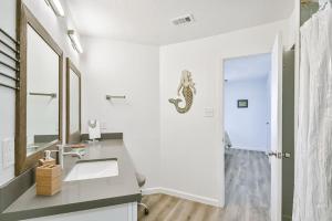 a bathroom with a sink and a snake on the wall at Baca Beach Escape II in Galveston +28 photos