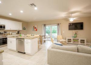 a kitchen and living room with a couch and a table at Beach Bliss - 5 MIN WALK to BEACH - Family Retreat in Daytona Beach Shores