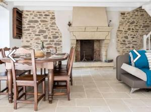a dining room with a table and a fireplace at Maison Ker Suliac in Saint-Suliac