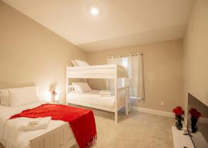 a bedroom with a white bunk bed with a red blanket at Beach Bliss - 5 MIN WALK to BEACH - Family Retreat in Daytona Beach Shores