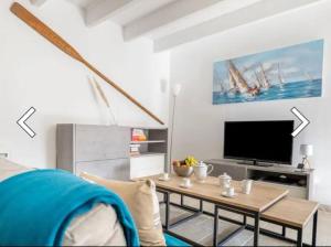a living room with a table and a tv at Maison Ker Suliac in Saint-Suliac +8 photos