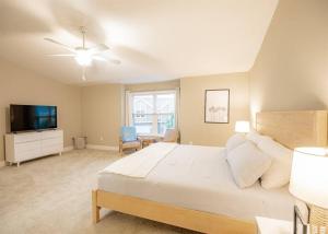 a bedroom with a large bed and a television at Beach Bliss - 5 MIN WALK to BEACH - Family Retreat in Daytona Beach Shores
