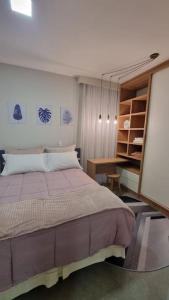 En eller flere senge i et værelse på Apartamento ensolarado em condomínio clube