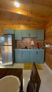 a kitchen with blue cabinets and a stainless steel refrigerator at كوخ السعاده happiness hut in Thuwal