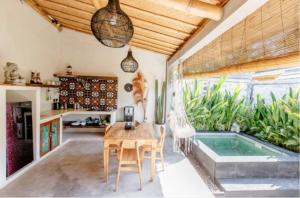 a dining room with a table and a swimming pool at Alma Surf Villas 01 - Cozy 01 Bed with Private Pool in Uluwatu